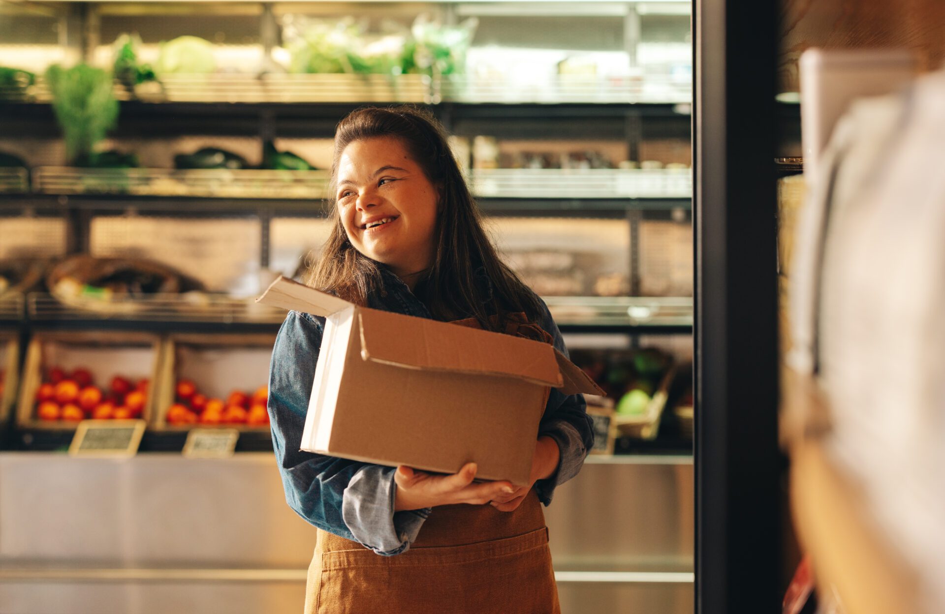Woman with Down syndrome smiling restocking food products